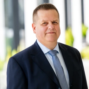 Dr. Rolandas Urbonas, Vytauto Didžiojo universiteto mokslo ir inovacijų prorektorius, konferencijos prane&scaron;ėjas. Portretinė nuotrauka &ndash; vyras su trumpais plaukais, dėvintis kostiumą. Jis &scaron;ypsosi ir žvelgia į kamerą. Fonas &ndash; &scaron;viesus.