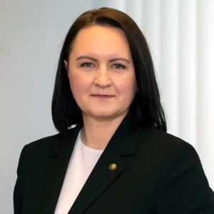 Edita Gudauskienė, Lietuvos Respublikos energetikos ministerijos viceministrė, konferencijos prane&scaron;ėja. Portretinė nuotrauka &ndash; moteris su tamsiais plaukais, dėvinti tamsų &scaron;varką. Ji žiūri į kamerą. Fonas &ndash; &scaron;viesus.