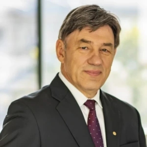 Prof. habil. dr. Juozas Augutis, Vytauto Didžiojo universiteto profesorius, konferencijos prane&scaron;ėjas. Portretinė nuotrauka &ndash; vyresnio amžiaus vyras su trumpais žilais plaukais, dėvintis kostiumą ir kaklarai&scaron;tį. Jis žiūri į kamerą. Fonas &ndash; &scaron;viesus.