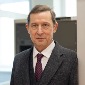 Prof. dr. Saulius Gudžius, Lietuvos energetikos instituto direktorius, konferencijos prane&scaron;ėjas. Portretinė nuotrauka &ndash; vyras su trumpais plaukais, dėvintis kostiumą ir kaklarai&scaron;tį. Jis žiūri į kamerą. Fonas &ndash; darbo aplinka.